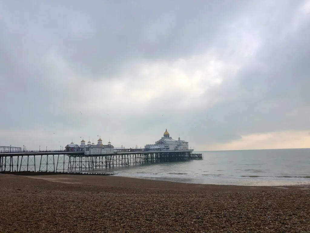pexels-photo-5116246-5116246 A moody shot of Eastbourne Pier under cloudy skies on a pebble beach.